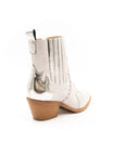 A white ankle boot with a heel, featuring a side zipper and decorative stitching detail.