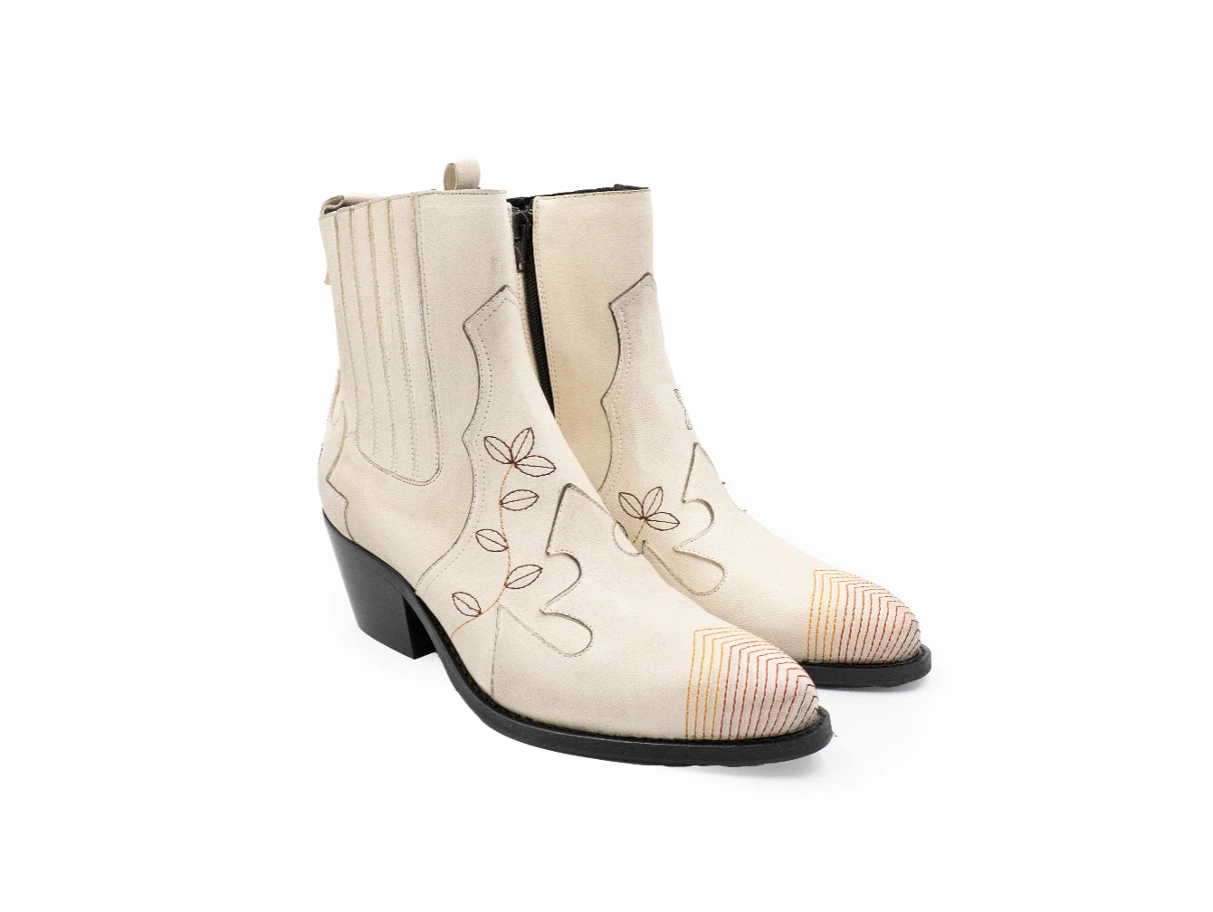 Pair of white cowboy boots with black accents on a white background