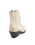 White cowboy boots with black soles on a white background