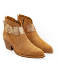 Pair of brown ankle boots with a decorative strap on a white background