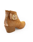 Brown ankle boot with decorative button on a white background