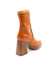 Tan ankle boot with a block heel on a white background
