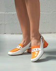 White and orange shoes on a plain background