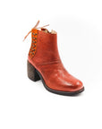 Brown leather boot with a textured sole on a white background
