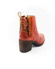 Brown leather boot with a block heel on a white background