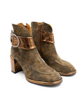 Pair of brown leather boots with gold accents on a white background