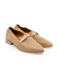 Pair of beige loafers with a decorative strap on a white background