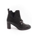 Black ankle boot with a decorative buckle on a white background