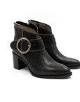 Pair of black textured boots with a circular buckle on a white background