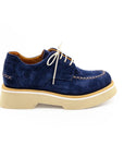 A blue suede shoe with a light-colored sole and lace-up closure, displayed against a white background.