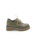 Green leather shoe with a platform sole on a white background