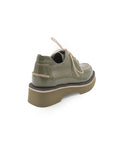Green leather shoe with a thick sole on a white background