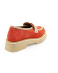 A red flat shoe with a white strap and a beige sole, designed for women.