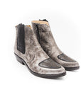 Pair of gray Chelsea boots with black zippers on a white background