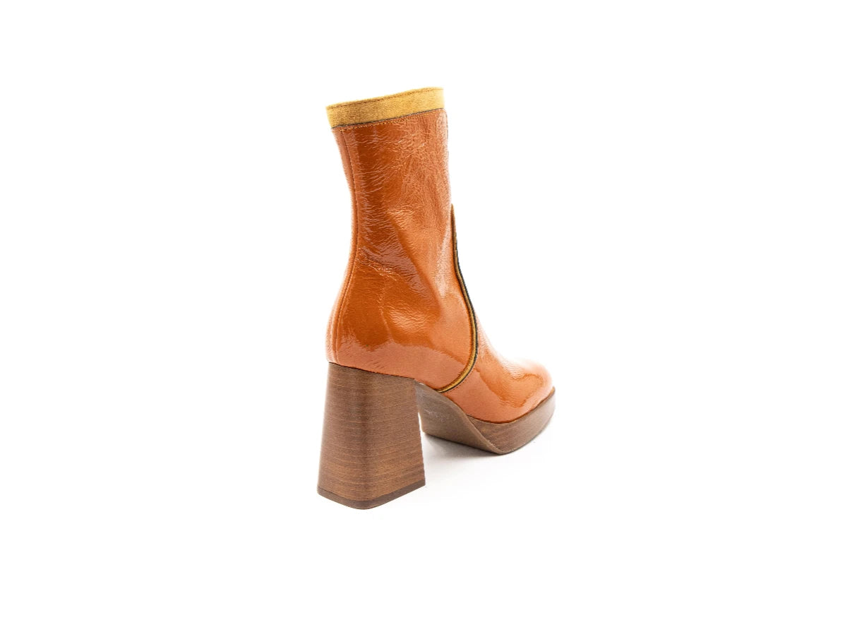 Tan ankle boot with a block heel on a white background