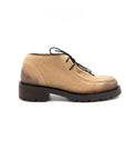 Tan leather shoe with black sole on a white background