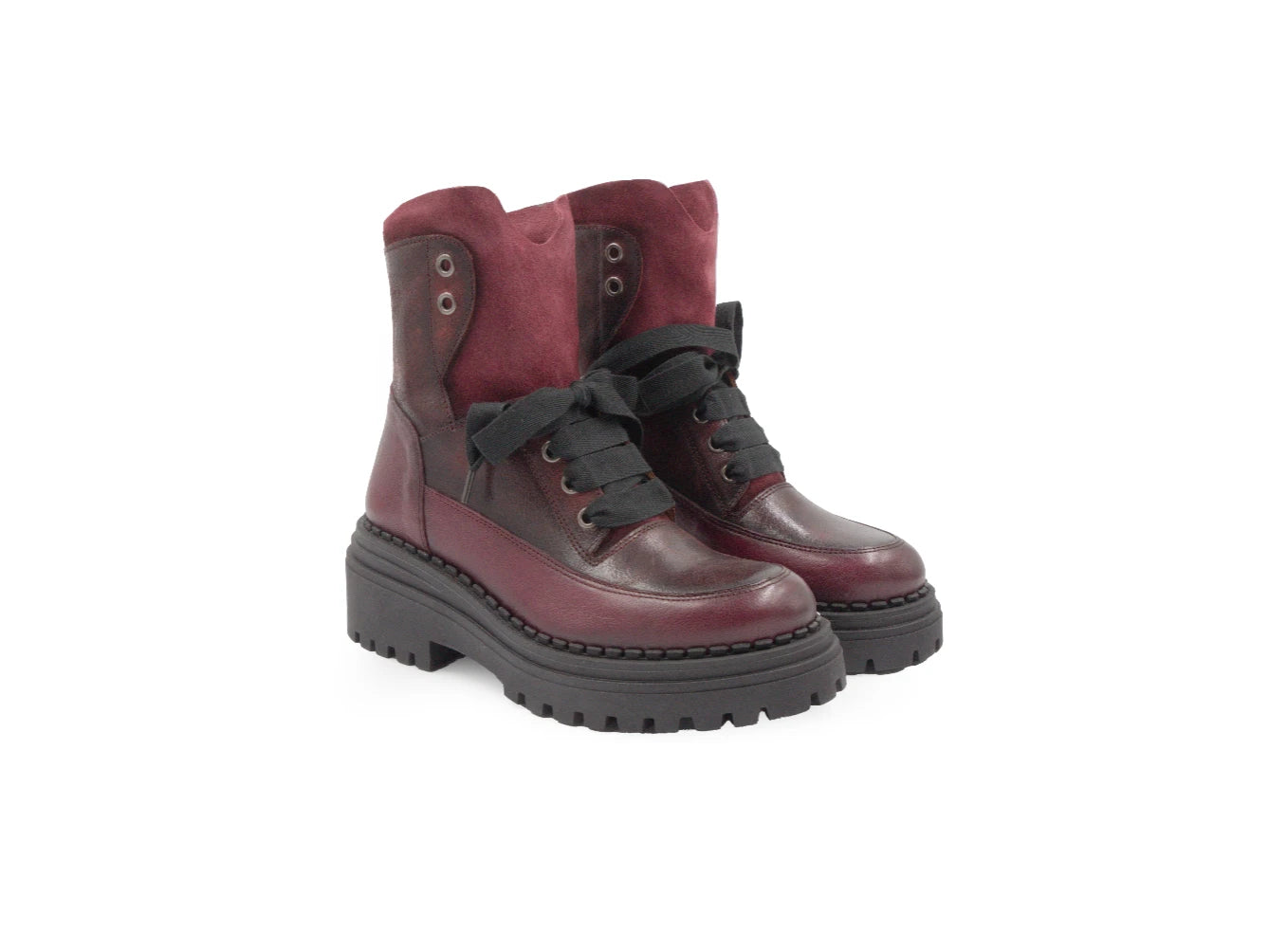 Pair of maroon boots with black soles on a white background